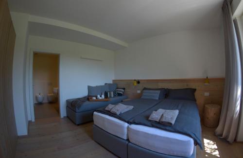 a bedroom with a large bed and a couch at APPARTAMENTO i Sentieri in Dro