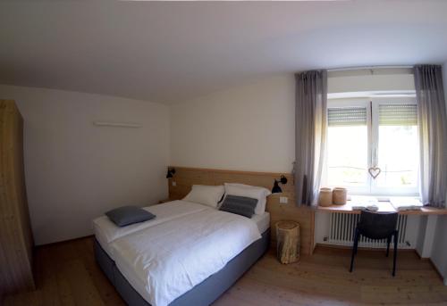 a bedroom with a bed and a desk and a window at APPARTAMENTO i Sentieri in Dro