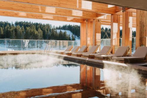 a group of chairs sitting next to a swimming pool at Viceroy Kopaonik Serbia in Kopaonik