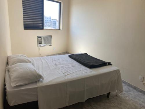 a white bed in a room with a window at Hotel Vitoria in Varginha