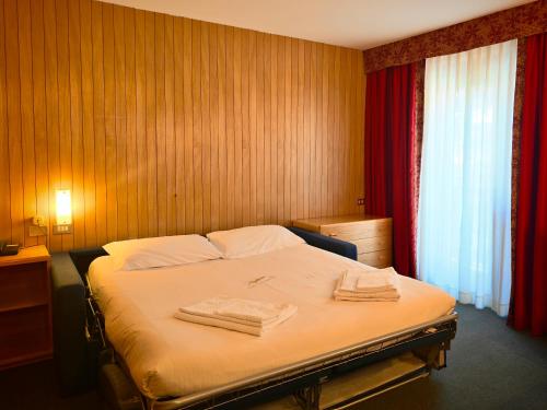 a bedroom with a bed with two towels on it at Residence Les Coupoles in Champoluc
