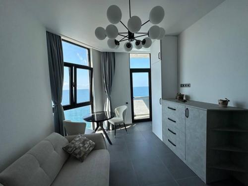a living room with a couch and a table and some windows at 11 Апартамент с отдельной спальней in Kvariati