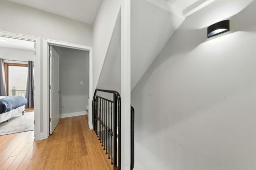 a hallway with white walls and a black iron staircase at Spacious 3-Bed West Loop Townhouse, 1 Car Garage in Chicago