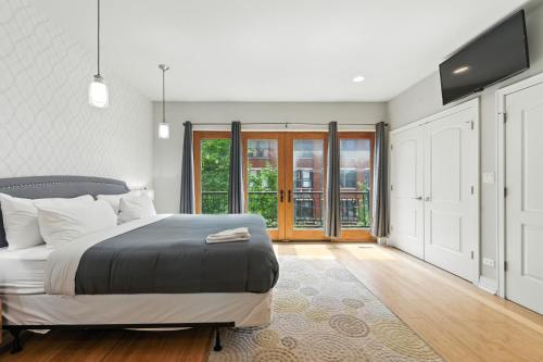 a bedroom with a bed and a large window at Spacious 3-Bed West Loop Townhouse, 1 Car Garage in Chicago