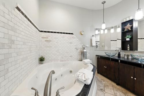 a white bathroom with a tub and a sink at Spacious 3-Bed West Loop Townhouse, 1 Car Garage in Chicago