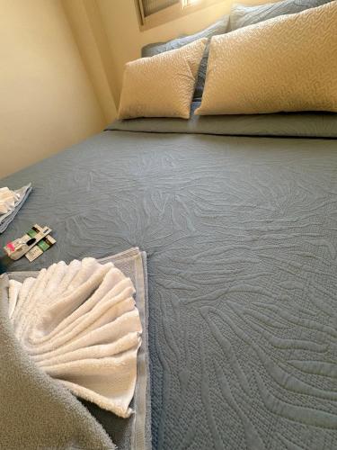 an unmade bed with two pillows on top of it at Apartamento Central in Passos