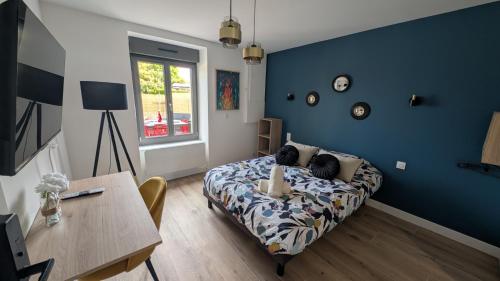 a bedroom with a bed and a table and a desk at Résidence Tamaris Paloma in Plouër-sur-Rance