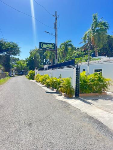 an empty street with a white fence and plants at Hotel1325 in Baní