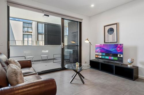 a living room with a couch and a tv at 3E1 Abnb-Style Cozy Epping Stay, Walk to Station, Free Parking in Epping