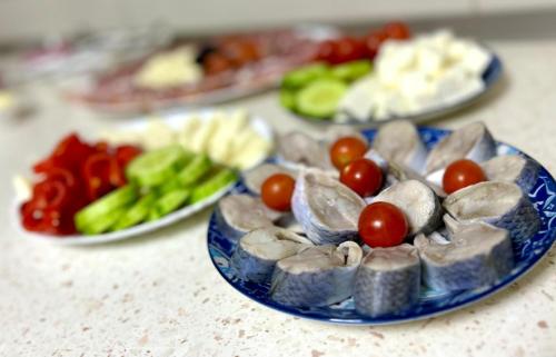 a blue plate of food with tomatoes and other vegetables at Casa Munteanu in Mila Douăzeci şi Trei