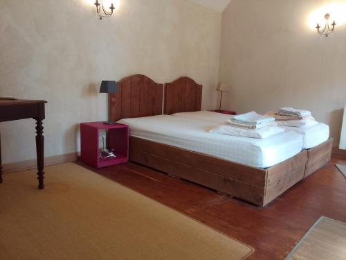 una camera da letto con un letto grande con testiera in legno di La bourguignonne a Villemanoche