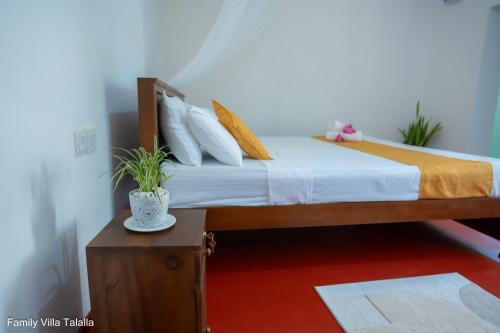 a bedroom with a bed with white sheets and pillows at Family Villa Talalla in Talalla
