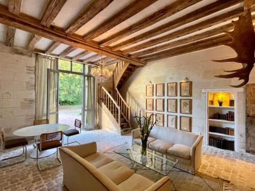 ein Wohnzimmer mit Sofa und Tisch in der Unterkunft Relais des Hautes Roches in Fondettes