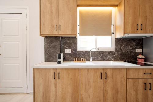 a kitchen with wooden cabinets and a sink at Lefko Fine Maisonettes in Kavos