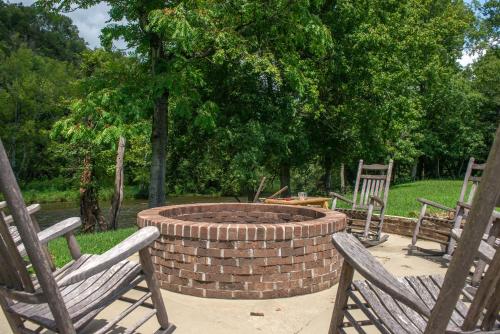 a fire pit in a yard with two rocking chairs at Cades Cove Landing Condo-Little River Loft in Townsend