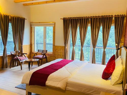 una camera da letto con un letto e una grande finestra di Vaayu Villa by Saanjh Stays a Rāmgarh