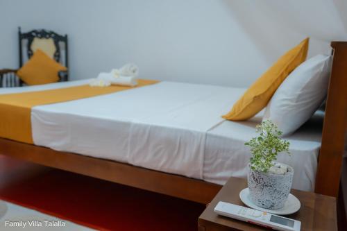 a bedroom with a bed with a plant on a table at Family Villa Talalla in Talalla