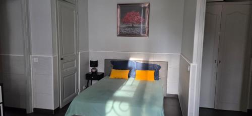 ein Schlafzimmer mit einem Bett und zwei gelben Kissen in der Unterkunft Charmant studio in Cannes