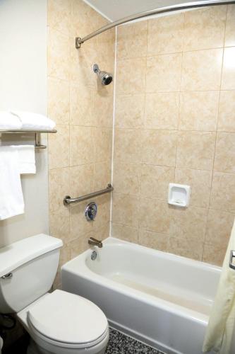 a bathroom with a toilet and a tub and a sink at Americas Best Value Inn Monroe in Monroe