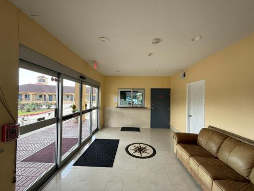 a living room with a couch and a large window at Budget Host Inn Stafford - Houston in Houston