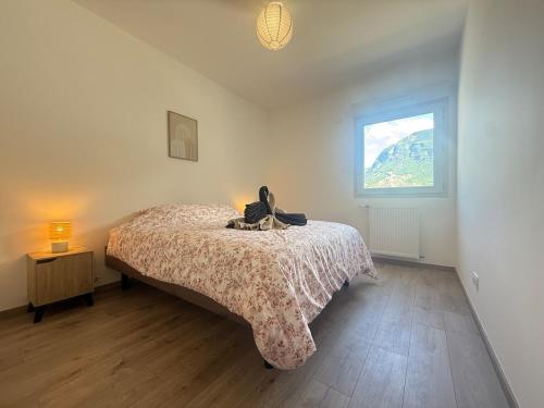 a bedroom with a bed with a stuffed animal on it at Le Moulin Balcon Proche Centre Calme in Saint-Jean-de-Maurienne