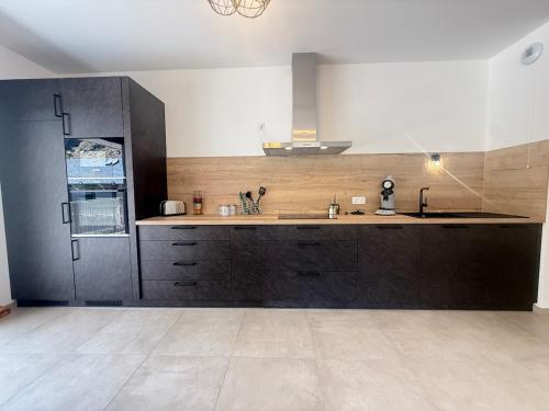 a kitchen with a sink and a counter top at Le Moulin Balcon Proche Centre Calme in Saint-Jean-de-Maurienne