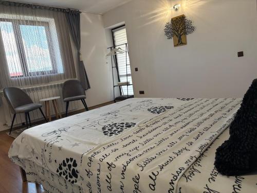 a bedroom with a bed with a black and white blanket at MIK Chalet in Săcele