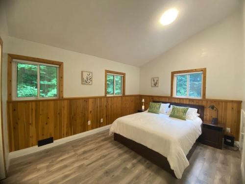 グレイブンハーストにあるCharcoal Tree Houseのベッドルーム1室(木製の壁と窓のあるベッド1台付)