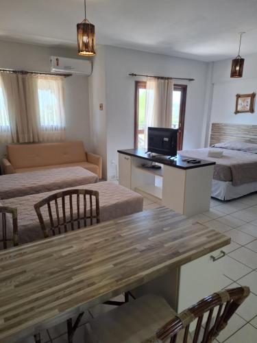 a room with two beds and a table with a television at Apart Hotel Serantes in Natal