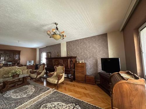 a living room with a couch and a television at Charming Ferizaj Villa in Ferizaj