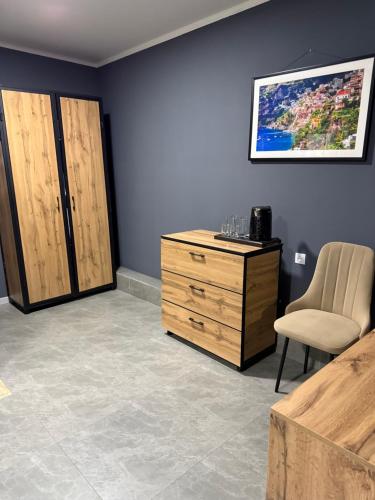a room with a wooden dresser and a chair at Loft Hotel in Fëdorovka