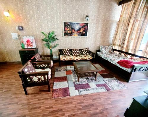 a living room with couches and a table at RB Cottage at mall road mussoorie in Mussoorie