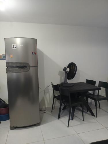 a refrigerator in a room with a table and chairs at Condomínio Villaggio di Como in Itamaracá