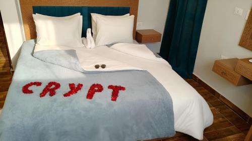 a bed with a comforter with the word crawl on it at The Pyramids Crypt Inn in Cairo