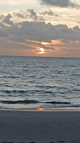 a sunset on the beach with the ocean at Condomínio Villaggio di Como in Itamaracá