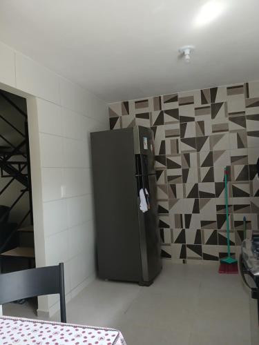 a refrigerator in a room with a geometric wall at Condomínio Villaggio di Como in Itamaracá