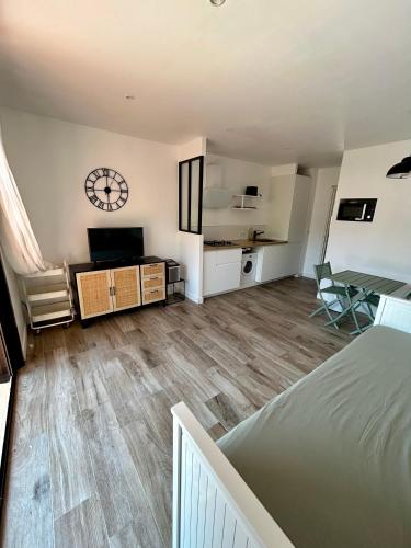 a living room with a bed and a clock on the wall at Les Marines, Castello Rosso vue mer - Accès plage à pied in Casaglione