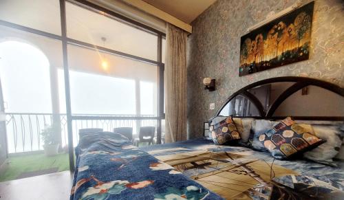 a bedroom with a bed and a large window at RB Cottage at mall road mussoorie in Mussoorie