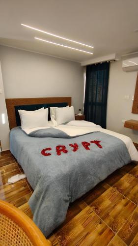 a bedroom with a bed with red flowers on it at The Pyramids Crypt Inn in Cairo