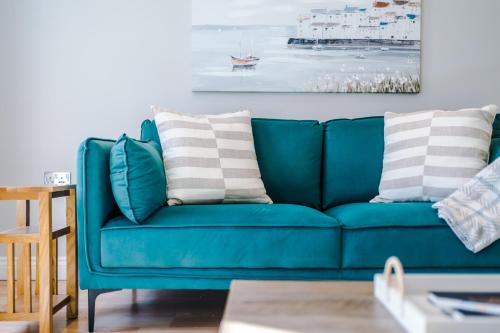 a blue couch with pillows on it in a living room at Charming Townhome Retreat, close to Manchester in Manchester