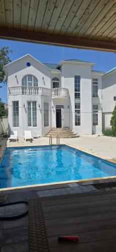 a large swimming pool in front of a house at Villa Riverside in Gabala