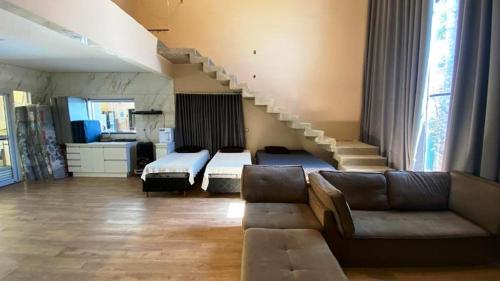 ein Wohnzimmer mit einer Couch und einer Treppe in der Unterkunft Sitio Silveira Nobre - São Joaquim de Bicas in São Joaquim de Bicas