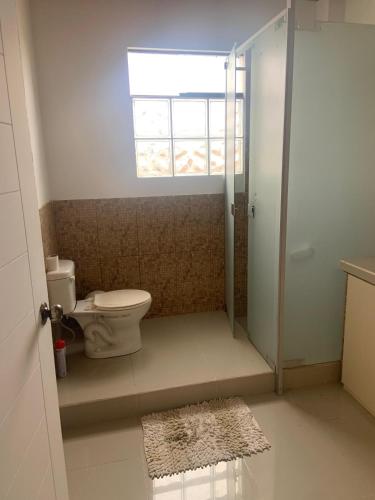 a bathroom with a toilet and a window at Casa Ruiz Ganoza in San Antonio