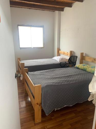 a bedroom with two twin beds and a window at Casa Ruiz Ganoza in San Antonio