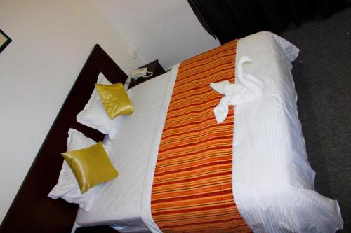 a large bed with white sheets and pillows at HALA HOTEL apartments in Sharjah