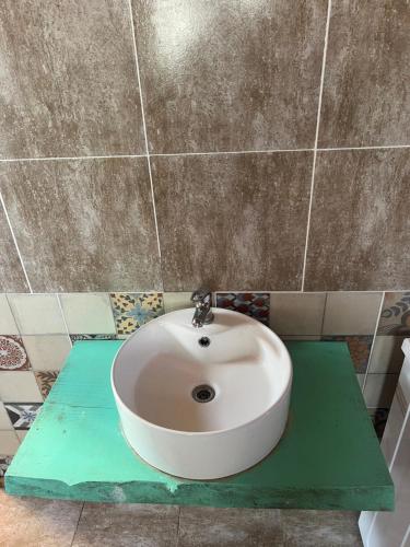 a white sink on a green counter in a bathroom at Domo Del Rio in Los Reartes