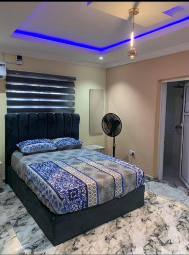 1 dormitorio con 1 cama extragrande con iluminación azul en Excell and be Great Homes, en Lagos