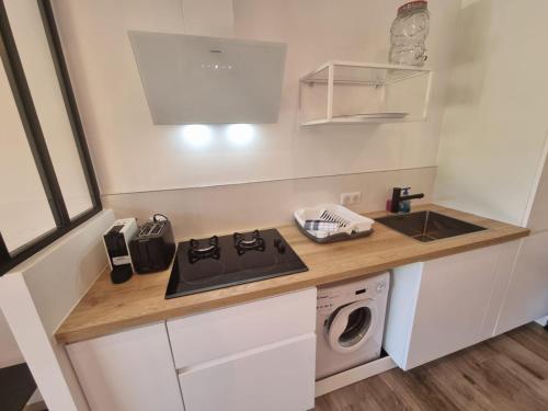 a small kitchen with a stove and a sink at Les Marines, Castello Rosso vue mer - Accès plage à pied in Casaglione