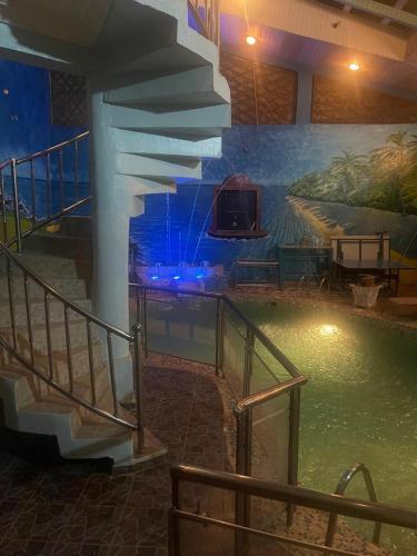 a room with a swimming pool with a painting on the wall at Platinum Palace Home in Benin City