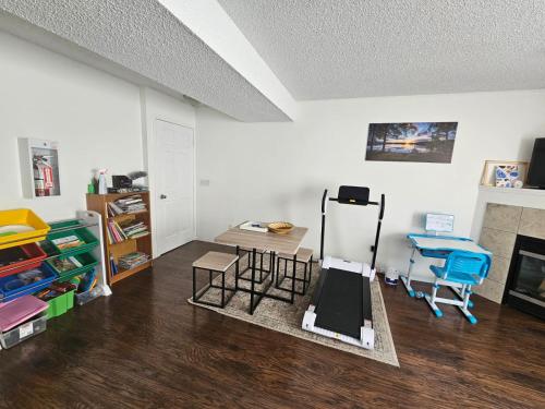 埃德蒙顿Basement Appartment的一间带椅子和桌子的房间以及壁炉